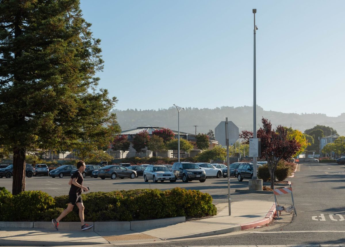 A jogger stride past the parking lot of the North Berkeley BART station