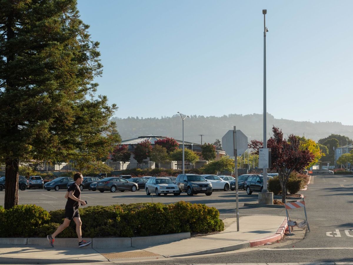A jogger stride past the parking lot of the North Berkeley BART station
