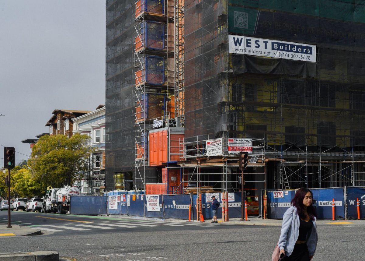 Pedestrians walk past a construction site in downtown Berkeley