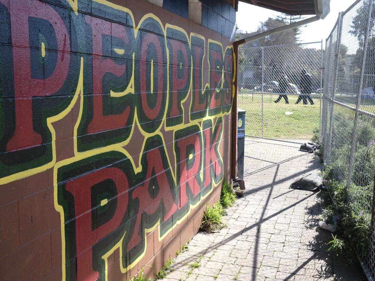 A sign for People's Park near fencing that went up